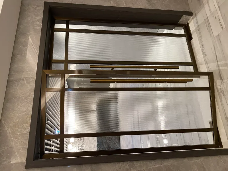 Brass-framed reeded glass double doors with grid pattern and long brass handles