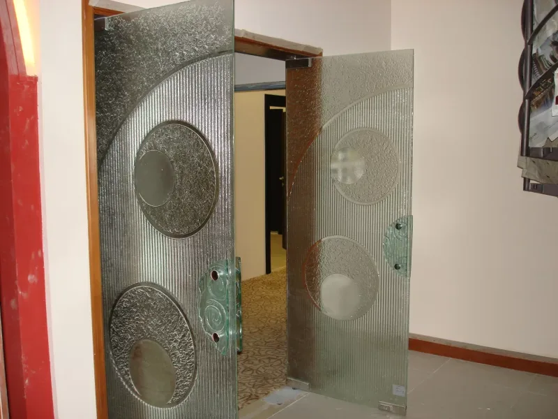 Pair of frameless decorative glass doors with circle relief pattern and reeded texture